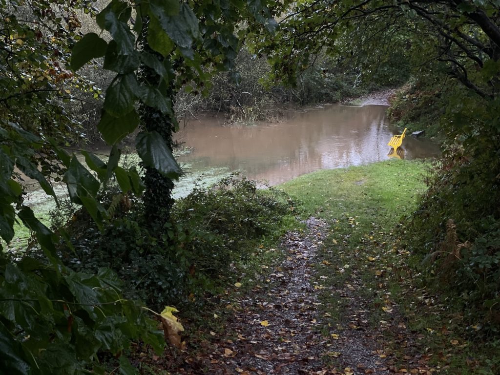 A photograph of a bench in flood water