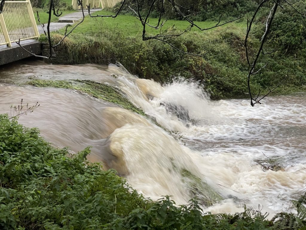 A photograph of water rushing under a bridge