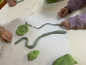 a child forming river shapes from play doh