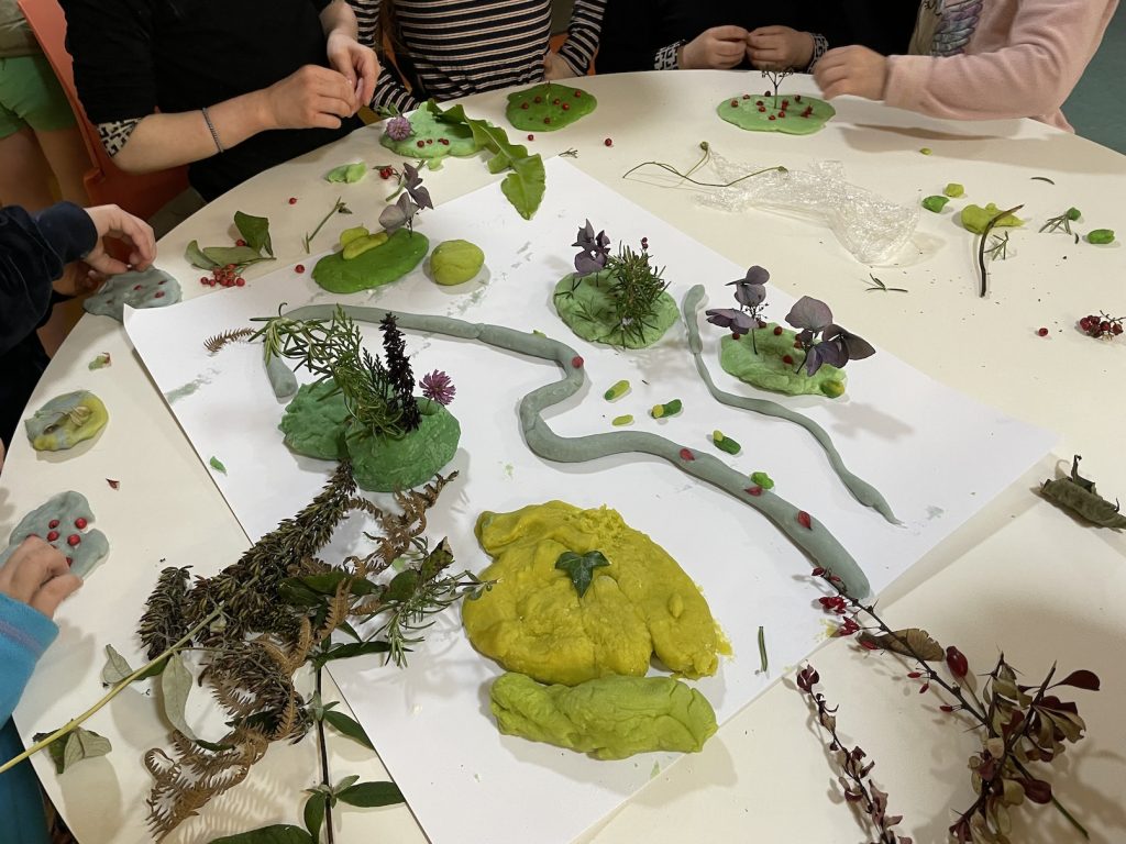 A table with children at work on a model of a river valley