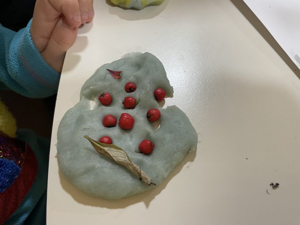 A piece of blue playdoh with red berries in it