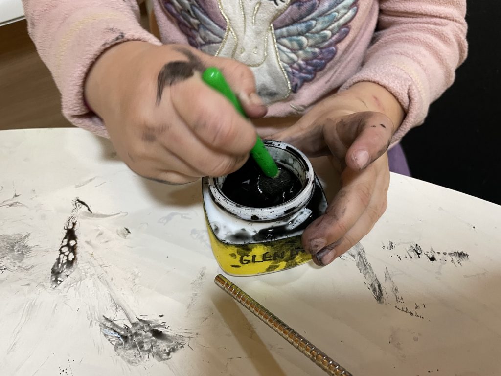 A child mixing ink in a pot