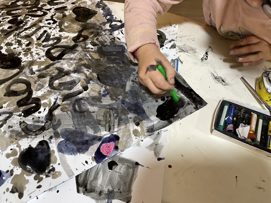 child painting with natural inks from blackberries and oakgalls and wax crayons