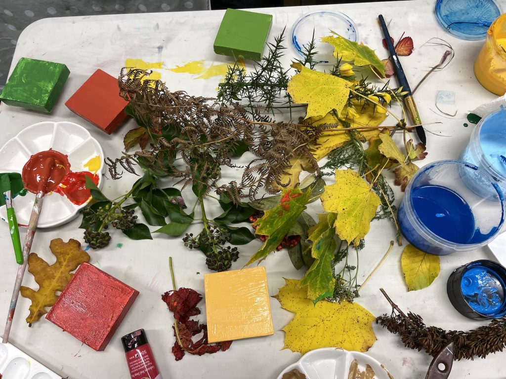 A photo of painted wooden blocks and autumn leaves