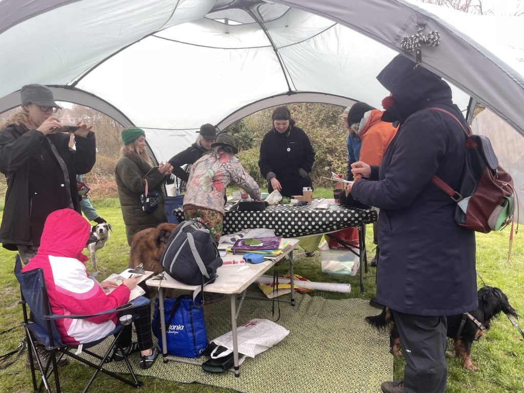 a photo of humans and dogs in a tent