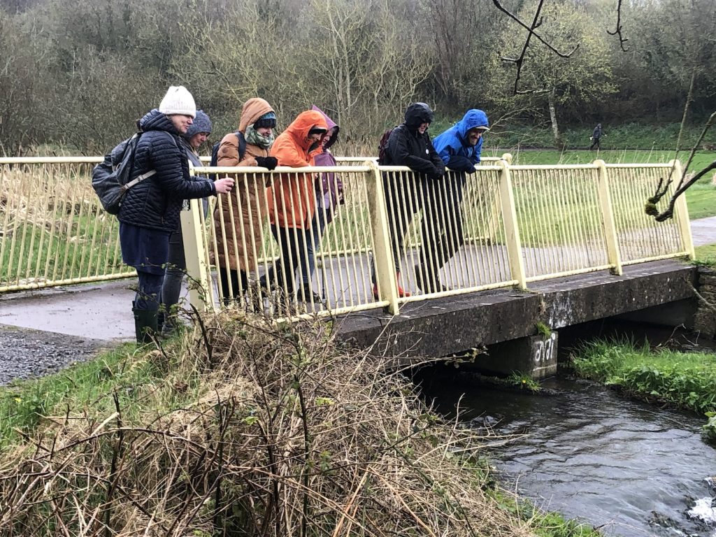 a photo of a group of people on a brdge over a river