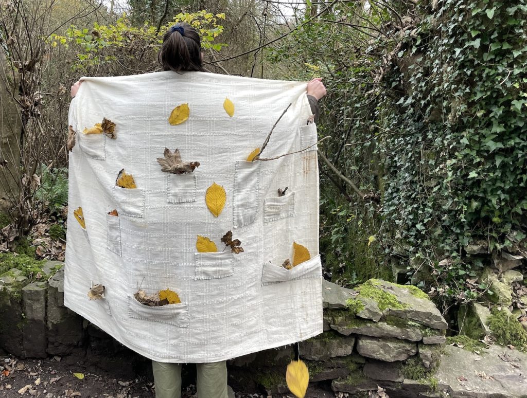 A person holding up a cloth with leaves on it