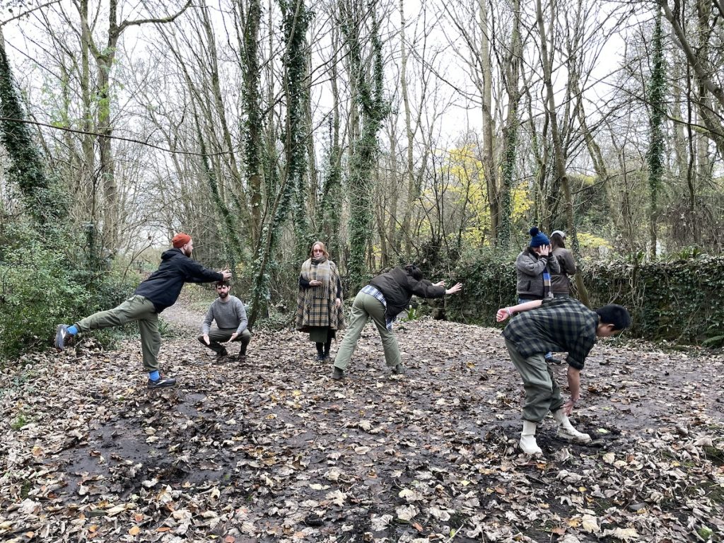 6 people posing in different ways in a wooded area