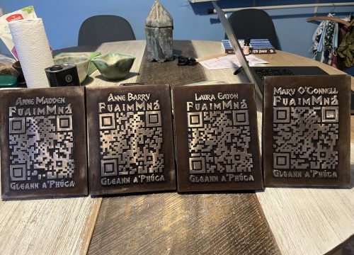 a photograph of bronze plaques with womens names and QR codes