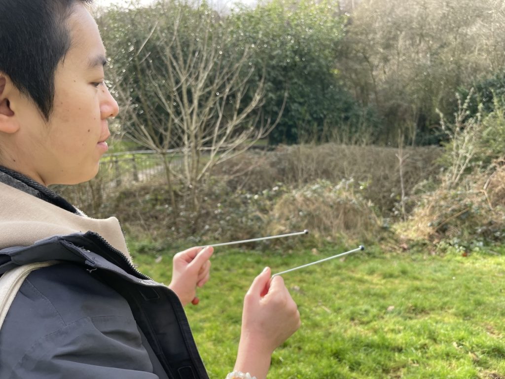 a participant holding the divining rods with eues closed