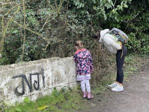 a photo of a child and a woman leaning over a bridge at a gate post