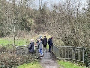 a photo of people listening at a bridge