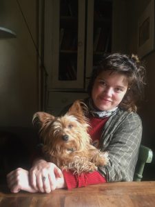 A photo of a woman and a dog at a kitchen table