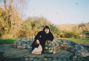 A photo of a woman posing near a mosaic Sculpture