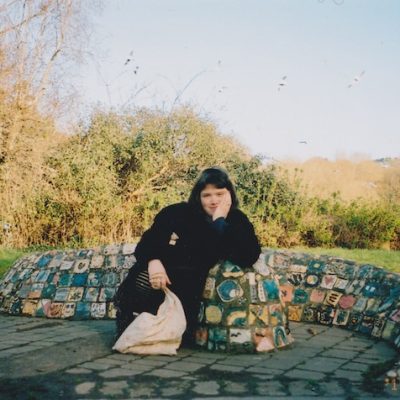 A photo of a woman posing near a mosaic Sculpture