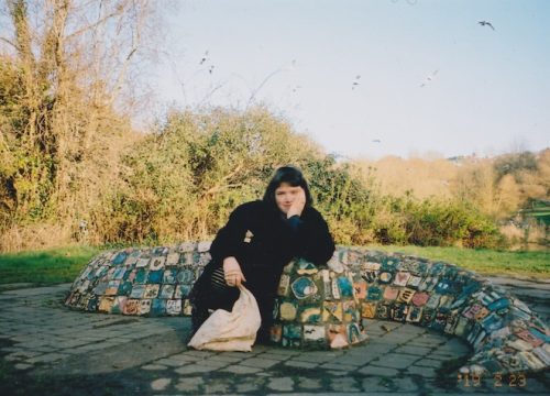 A photo of a woman posing near a mosaic Sculpture