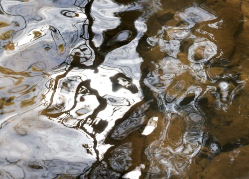 a photo clos-up of river water showing reflected patterns